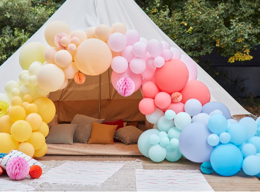 Colourful pastel shade latex balloon arch on a tipi entrance